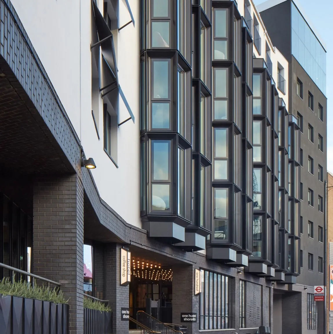 Facade with projecting black-framed bay window units